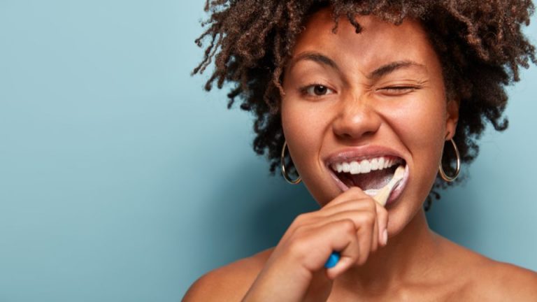 A Girl With Curly Hair Brushing Teeth