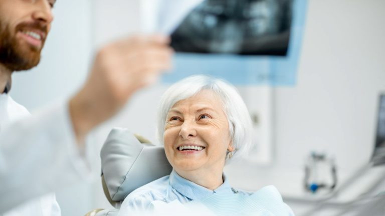 Dentist Displaying X-ray To Patient At Clinic